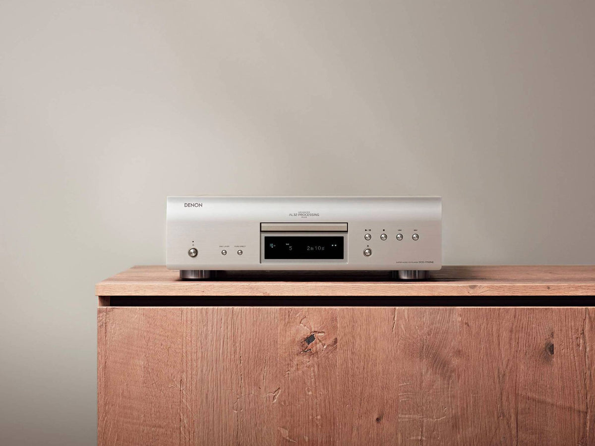 Denon DCD-1700NE CD/SACD player: silver player on a wooden cabinet, front view