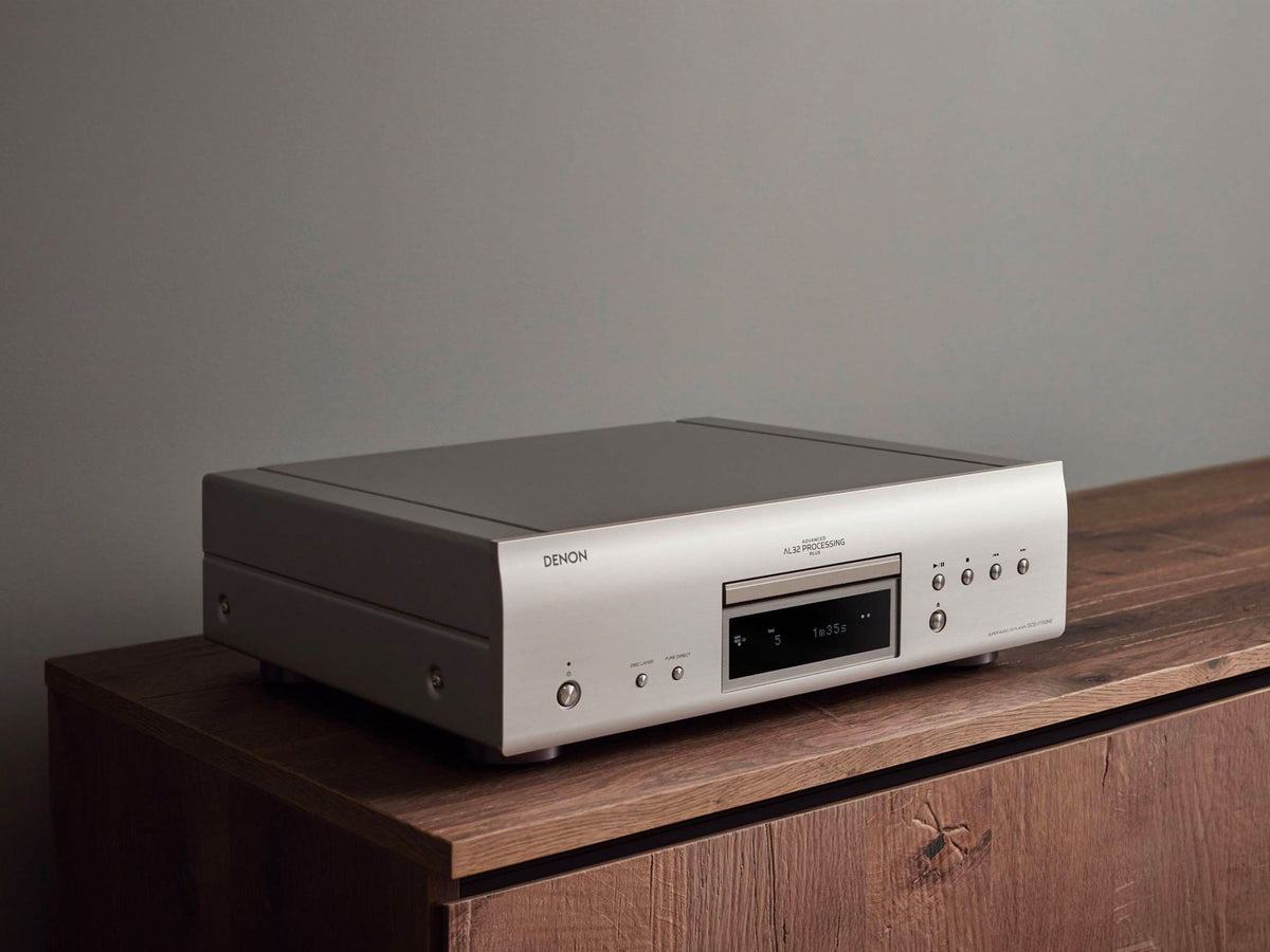 Denon DCD-1700NE CD/SACD player: silver player on a cabinet, top angled view