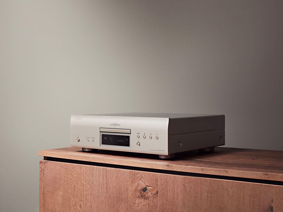 Denon DCD-1700NE CD/SACD player: silver player on a wooden cabinet, right angled view
