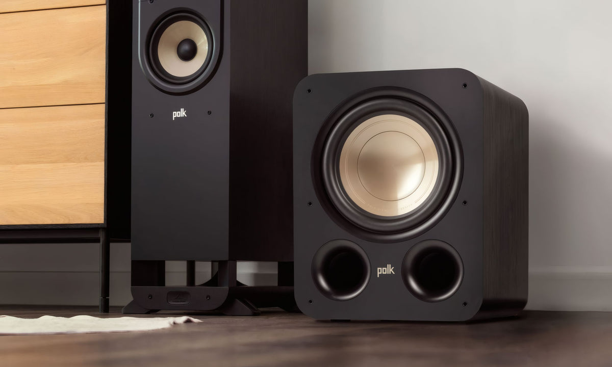 Polk Audio Signature Elite ES10 powered subwoofer, beside a floorstanding speaker